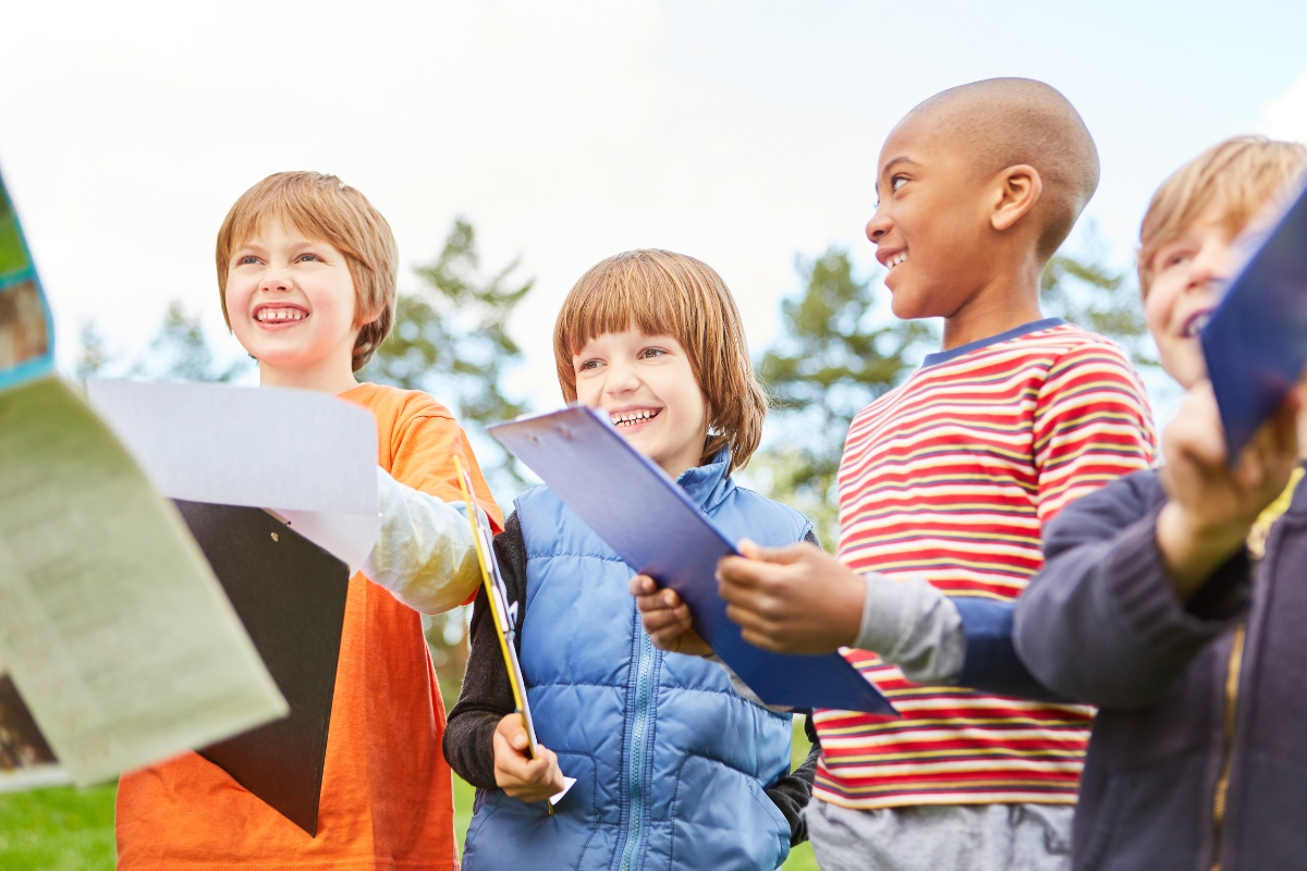 Four children holding clip boards.